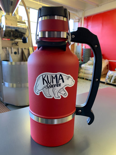 growler, on which a dye cut sticker of an illustration of a walking bear with the text kuma coffee written on it